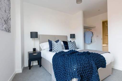 a bedroom with a bed and a blue blanket at Vox Apartments, Manchester, M15 4YD