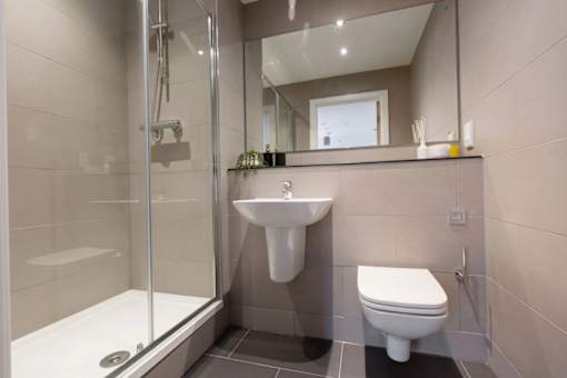 a bathroom with a toilet sink and shower at Vox Apartments, Manchester