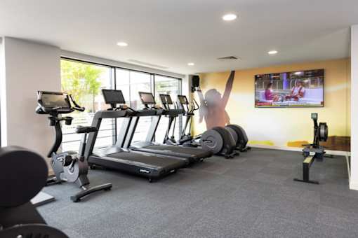 a gym with cardio equipment and a tv on the wall at The Trilogy Apartments, Manchester, M15 4RU