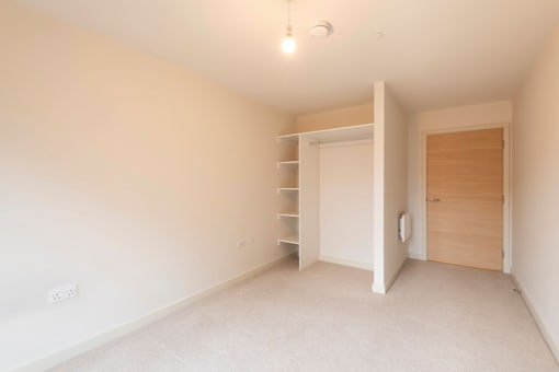 a bedroom with white walls and a closet and a door at The Trilogy Apartments, Manchester, M15 4RU