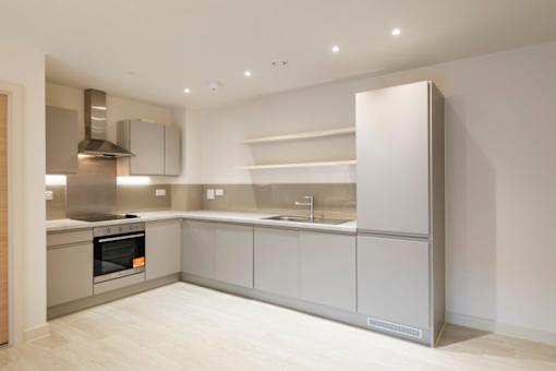 a kitchen with white cabinets and a stove and a refrigerator at The Trilogy Apartments, Manchester