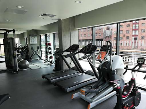 A gym with treadmills, exercise bikes, and other equipment.at Slate Yard Apartments, Salford