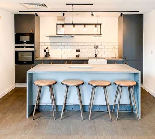 A kitchen with a bar stool in front of the counter.at Slate Yard Apartments, Salford, M3 5EX