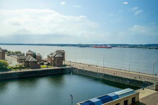 a large body of water with a dock and a boat in the water at The Keel Apartments, Liverpool, L3 4GE