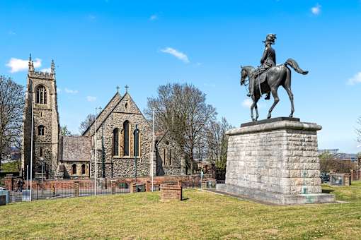 A statue of a man on a horse stands in front of a church.at The Quarters Apartments, Dock Road
