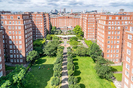 A view of a courtyard surrounded by red brick buildings.