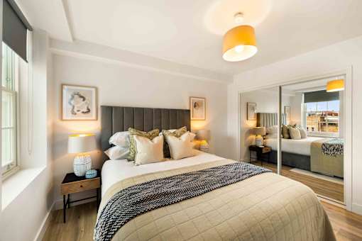 A bedroom with a large bed and a window.
