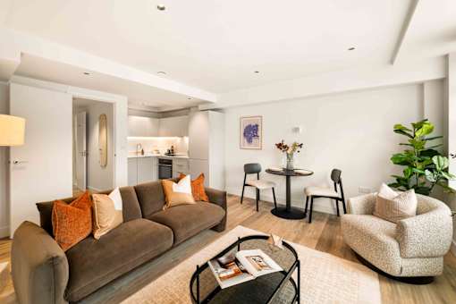 A living room with a brown couch, a round table, and a chair.