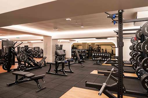 A gym with a variety of equipment including weights and machines.
