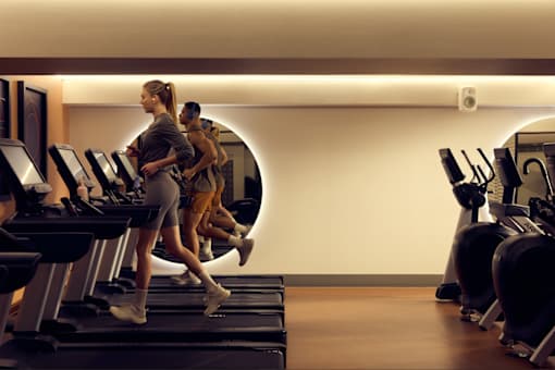 A woman is running on a treadmill in a gym.