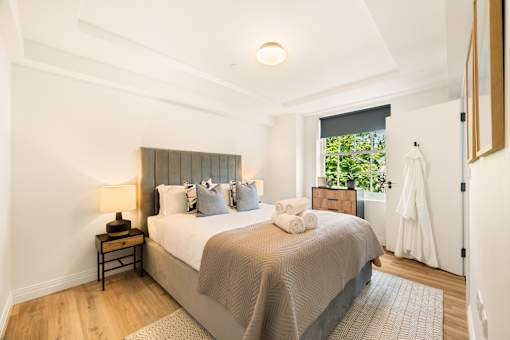 A bedroom with a large bed and a window.