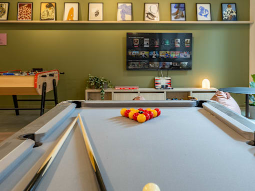 a game room with a pool table and a tv