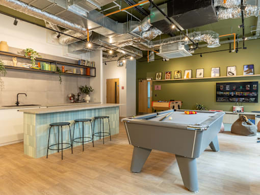 a game room with a pool table and a bar