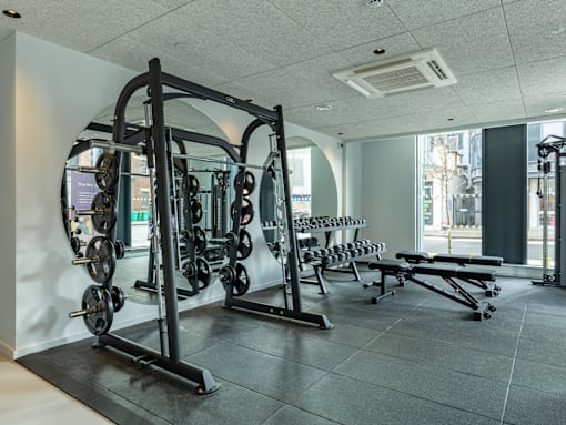 a gym with weights and other exercise equipment in the corner of a room