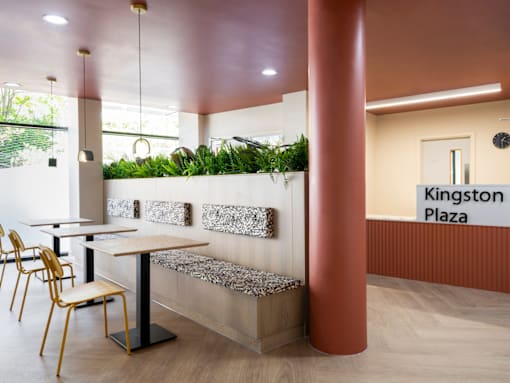 a restaurant with tables and chairs and a counter with plants on the wall