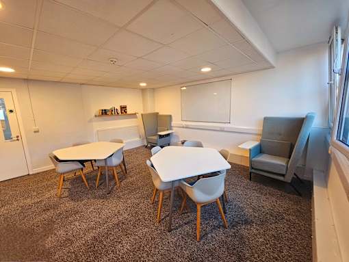 a room with a table and chairs and a window