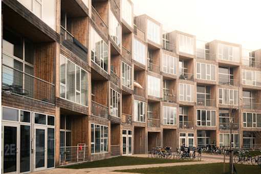 a row of apartment buildings with balconies and bikes parked outside of them