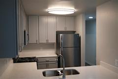 A kitchen with a stainless steel refrigerator and a sink.