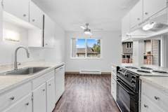 A kitchen with white cabinets and a black stove top oven.