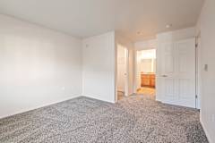 A room with a carpeted floor and white walls.