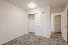 A white door is in the center of a room with a carpet floor.