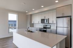 A modern kitchen with a large island and stainless steel appliances.
