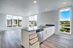 A modern kitchen with a large island and a view of the city.