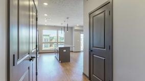 Hallway leading into the open and naturally bright living and dining space at Haven at Uptown in Lincoln, NE