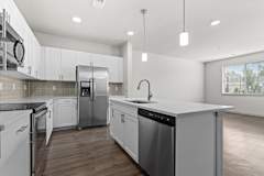 Renovated kitchen with white cabinets and stainless steel appliances at The Point at Biscay, Aurora, Colorado