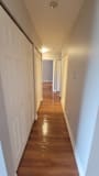 A long hallway with a white door at the end.
