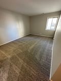 an empty room with a carpeted floor and a window