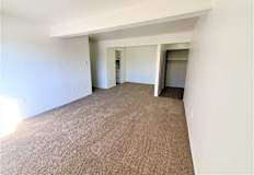 A living room and dining room with carpeted floor and white walls.