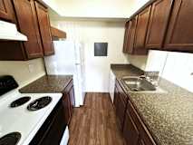 A kitchen with dark wood cabinets and granite countertops.