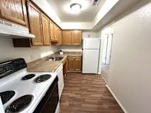 A kitchen with a white stove top oven and white refrigerator.
