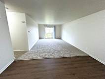 A living room with carpeted floors and white walls.