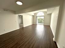 Spacious living room with arched balcony door at Heatherwood Apartments, Grand Blanc, 48439