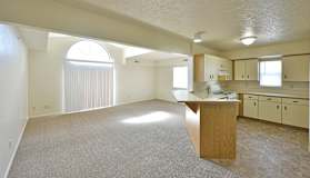 Open living room and kitchen with peninsula breakfast bar at Heatherwood Apartments, Grand Blanc