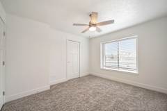 Bedroom with a ceiling fan and large window at Dupont Lakes Apartments in Fort Wayne, IN