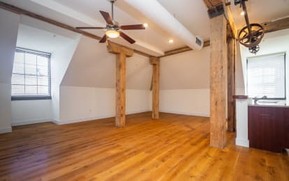 an open living room with exposed wood beams and a ceiling fan