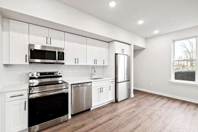 A kitchen with white cabinets and stainless steel appliances.