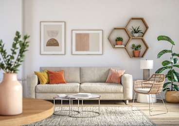 A living room with a grey couch, a coffee table, and a plant.