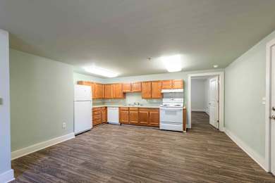 A kitchen with wooden cabinets and white appliances.at Kinston Hotel Apartments, Kinston North Carolina