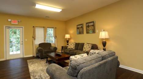 A living room with a grey couch, a brown coffee table, and a lamp at Robinson Park Apartments, Harrisonburg 22801