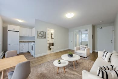 A living room with a white couch and a dining table.