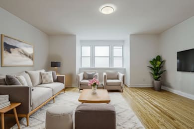 A living room with a grey couch, a brown coffee table, and a painting on the wall.