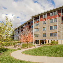 A large apartment building with a walkway in front of it.