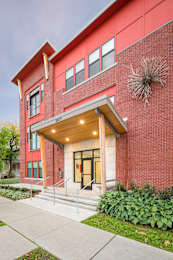 A red brick building with a wooden overhang and a glass door.