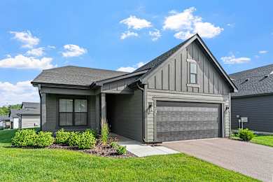 A house with a grey garage door and a grey roof.