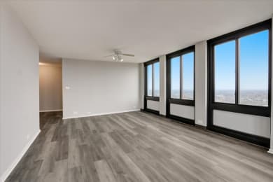 Floor Plan  an empty living room with a ceiling fan and a view of the city
