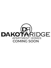 A black and white image of a sign that says Dakota Ridge Apartment Homes Coming Soon.